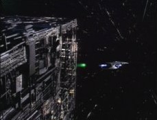 A Borg Cube fires a shield neutralizer "pellet" at a fleeing Galaxy class starship.